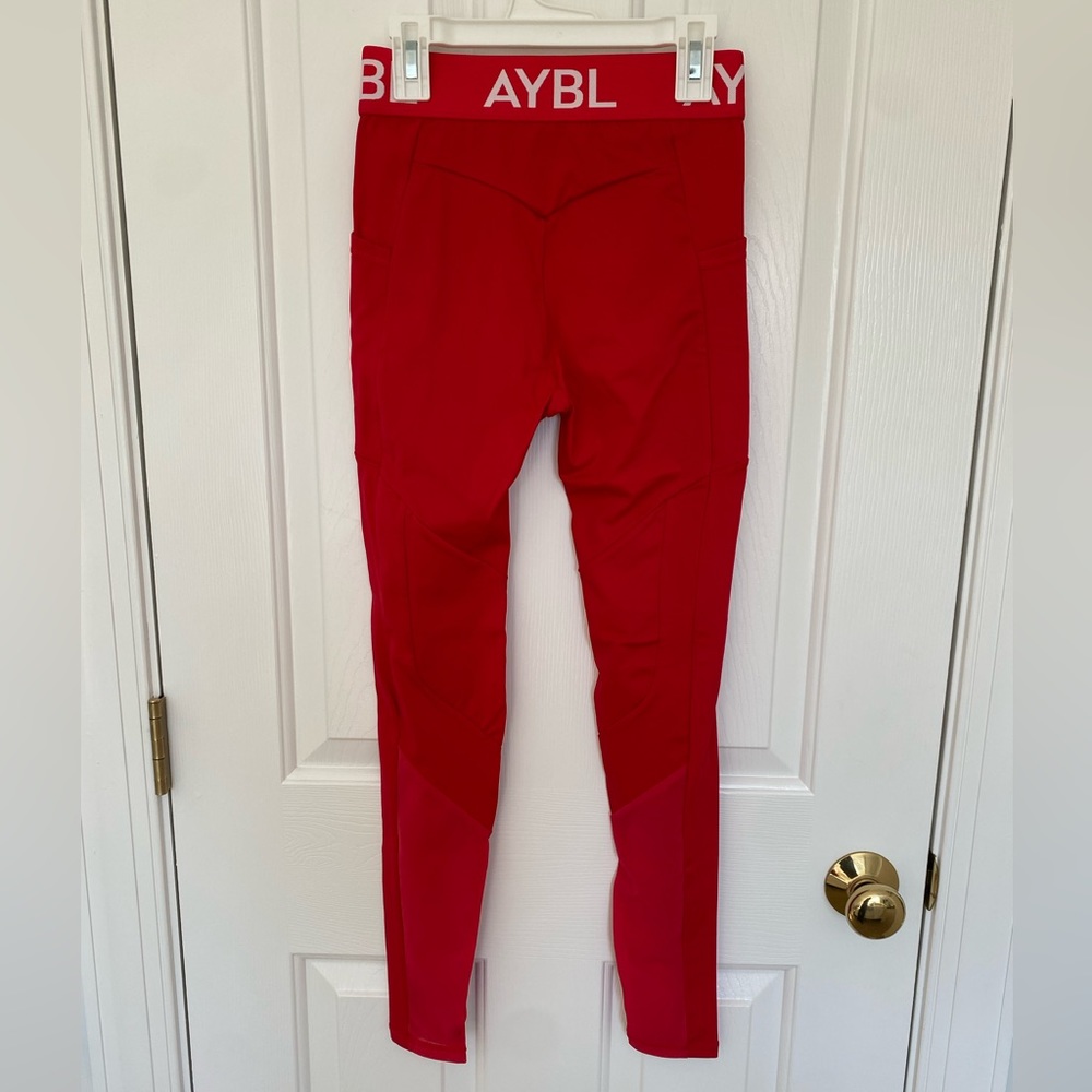 Bright red. Athletic wear. Side pockets and mesh paneling on calves